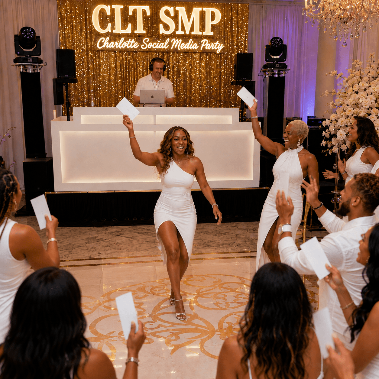 People in white outfits dance and hold cards at the Charlotte Social Media Party.